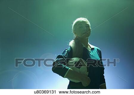Mature woman holding football, backlit View Large Photo Image Stock Image - Mature woman holding football, backlit. Fotosearch