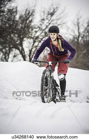 Mid adult female mountain biker struggling to ride through snow View Large Photo Image Stock Image - Mid adult female mountain biker struggling to ride through snow. Fotosearch