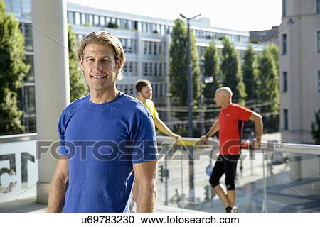 Mid adult male trainer and class taking a break on city rooftop View Large Photo Image Stock Image - Mid adult male trainer and class taking a break on city rooftop. Fotosearch