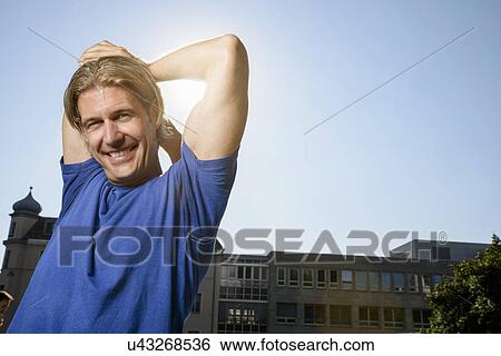 Mid adult man stretching during training on city rooftop View Large Photo Image Stock Photograph - Mid adult man stretching during training on city rooftop. Fotosearch