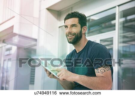 Mid adult man using touchscreen on digital tablet with lights View Large Photo Image Stock Photograph - Mid adult man using touchscreen on digital tablet with lights. Fotosearch