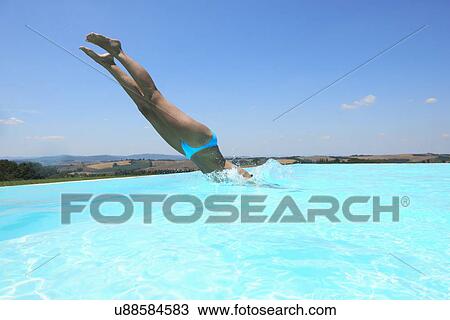 Mid adult woman diving into swimming pool View Large Photo Image Stock Image - Mid adult woman diving into swimming pool. Fotosearch