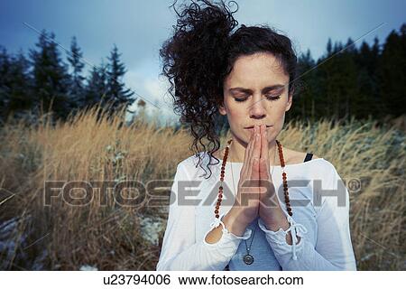 Mid adult woman meditating in forest View Large Photo Image Stock Photograph - Mid adult woman meditating in forest. Fotosearch