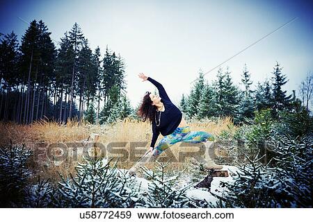 Mid adult woman practicing yoga in forest View Large Photo Image Stock Photo - Mid adult woman practicing yoga in forest. Fotosearch