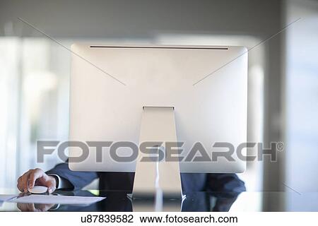 Mid adult woman working behind computer at desk View Large Photo Image Stock Image - Mid adult woman working behind computer at desk. Fotosearch