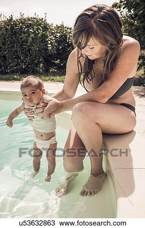 Mother and baby daughter paddling in swimming pool View Large Photo Image Stock Image - Mother and baby daughter paddling in swimming pool. Fotosearch