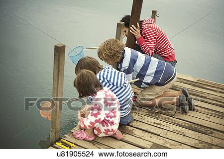 Picture - Mother and children fishing from pier, Southwold, Suffolk, UK. Fotosearch