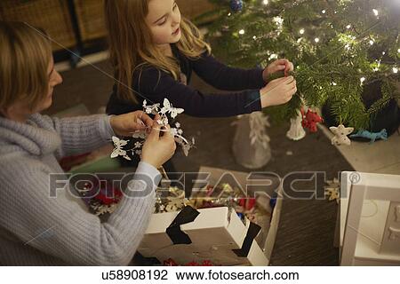 Mother and daughter decorating christmas tree View Large Photo Image Stock Image - Mother and daughter decorating christmas tree. Fotosearch
