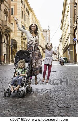 Mother and daughter, jumping in street, Bologna, Italy View Large Photo Image Stock Image - Mother and daughter, jumping in street, Bologna, Italy. Fotosearch