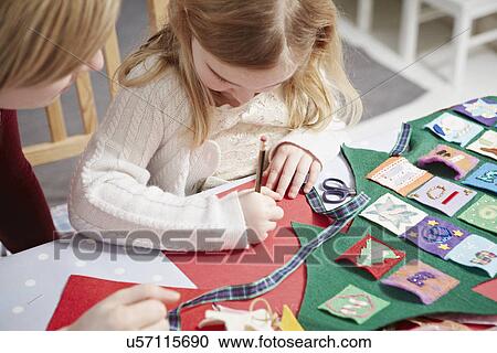 Mother and daughter making advent calendar at kitchen table View Large Photo Image Stock Image - Mother and daughter making advent calendar at kitchen table. Fotosearch