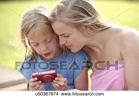 Picture - Mother and daughter reviewing photographs on digital camera. Fotosearch