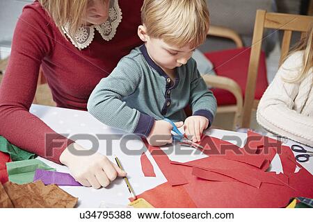 Mother and son craft making at kitchen table View Large Photo Image Stock Photo - Mother and son craft making at kitchen table. Fotosearch