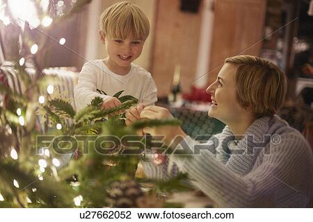 Stock Image - Mother and son decorating christmas tree. Fotosearch