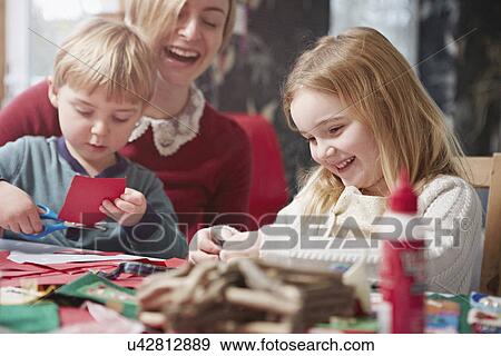 Mother and two children crafting at kitchen table View Large Photo Image Stock Photo - Mother and two children crafting at kitchen table. Fotosearch