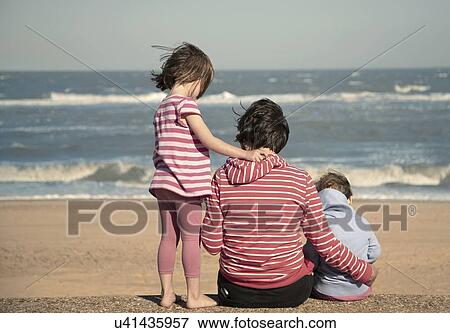 Mother and young daughters sitting on beach, Southwold, Suffolk, UK View Large Photo Image Stock Photo - Mother and young daughters sitting on beach, Southwold, Suffolk, UK. Fotosearch