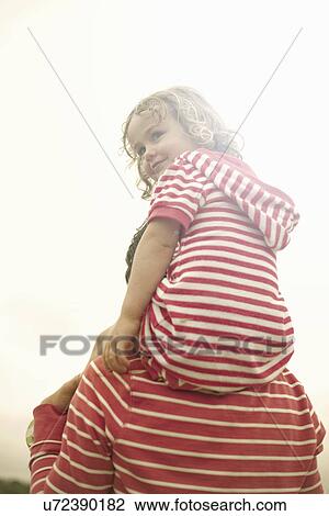 Mother carrying toddler daughter on shoulders View Large Photo Image Stock Image - Mother carrying toddler daughter on shoulders. Fotosearch