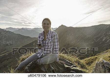 Portrait of a mid adult woman backpacker with smartphone, Achensee, Tyrol, Austria View Large Photo Image Stock Photograph - Portrait of a mid adult woman backpacker with smartphone, Achensee, Tyrol, Austria. Fotosearch
