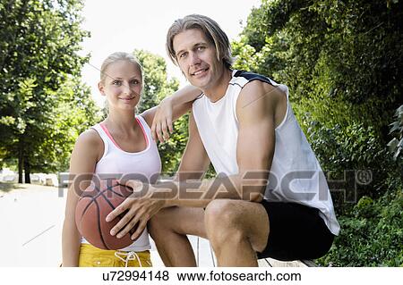 Stock Photo - Portrait of basketball couple taking a break in park. Fotosearch