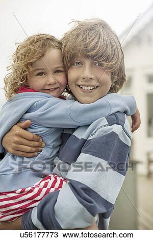 Portrait of boy and toddler sister hugging View Large Photo Image Stock Image - Portrait of boy and toddler sister hugging. Fotosearch