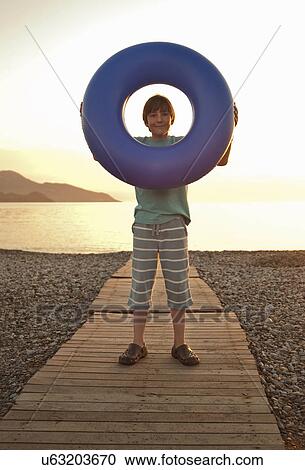 Portrait of boy holding up rubber ring, Fethiye, Turkey View Large Photo Image Stock Image - Portrait of boy holding up rubber ring, Fethiye, Turkey. Fotosearch
