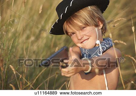 Portrait of boy in cowboy hat pointing toy gun View Large Photo Image Stock Photo - Portrait of boy in cowboy hat pointing toy gun. Fotosearch