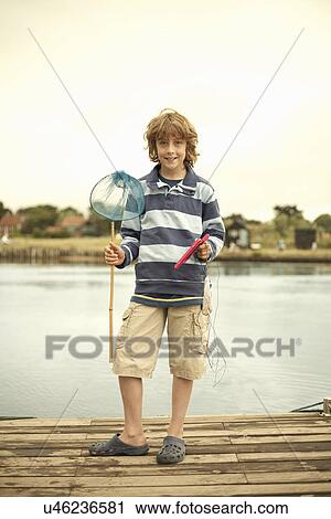 Portrait of boy on pier with fishing net, Southwold, Suffolk, UK View Large Photo Image Stock Image - Portrait of boy on pier with fishing net, Southwold, Suffolk, UK. Fotosearch