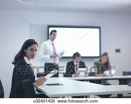 Stock Photography - Portrait of businesswoman in meeting room with screen. Fotosearch