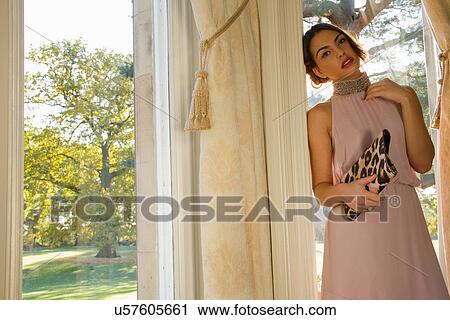 Portrait of glamorous young woman leaning against garden window View Large Photo Image Stock Image - Portrait of glamorous young woman leaning against garden window. Fotosearch
