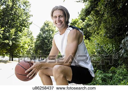 Portrait of male basketball player taking a break in park View Large Photo Image Stock Photo - Portrait of male basketball player taking a break in park. Fotosearch