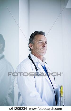 Picture - Portrait of male doctor holding medical notes. Fotosearch