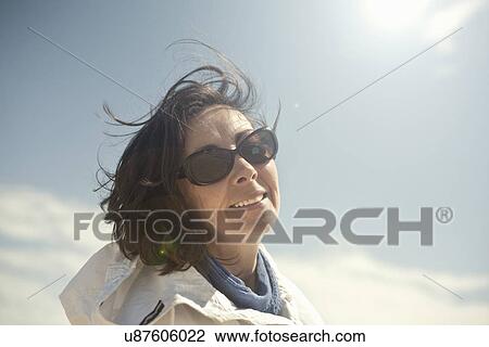 Stock Image - Portrait of mature woman in sunglasses. Fotosearch