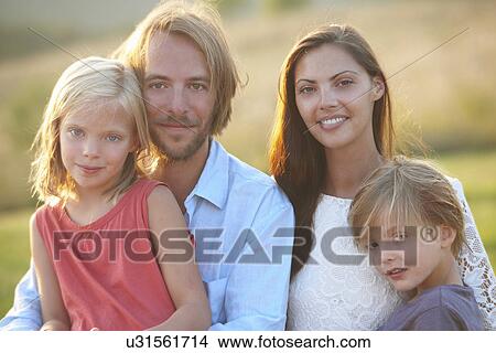 Portrait of mid adult couple and two children outdoors View Large Photo Image Picture - Portrait of mid adult couple and two children outdoors. Fotosearch
