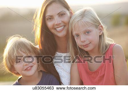 Portrait of mid adult mother and two children outdoors View Large Photo Image Stock Image - Portrait of mid adult mother and two children outdoors. Fotosearch