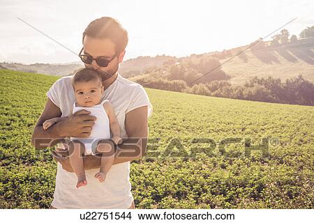 Portrait of proud father holding up baby daughter View Large Photo Image Picture - Portrait of proud father holding up baby daughter. Fotosearch
