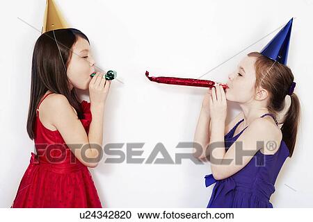 Portrait of two girls blowing party blowers View Large Photo Image Stock Image - Portrait of two girls blowing party blowers. Fotosearch