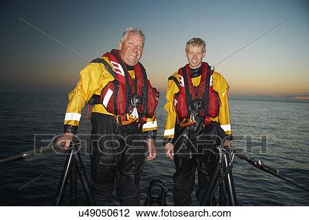 Portrait of two men crewing lifeboat at sea View Large Photo Image Stock Image - Portrait of two men crewing lifeboat at sea. Fotosearch