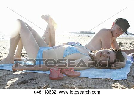 Portrait of young couple lying on beach View Large Photo Image Stock Image - Portrait of young couple lying on beach. Fotosearch