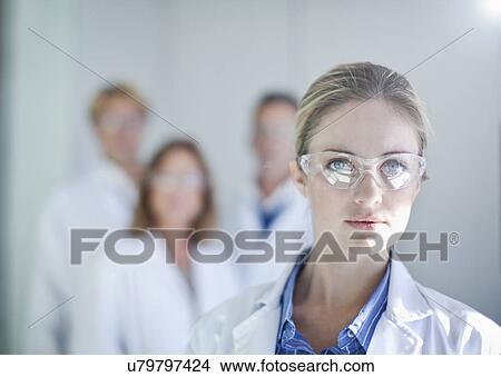Picture - Portrait of young female scientist wearing safety glasses. Fotosearch