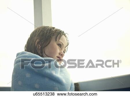 Stock Photo - Portrait of young girl wrapped in a blanket. Fotosearch