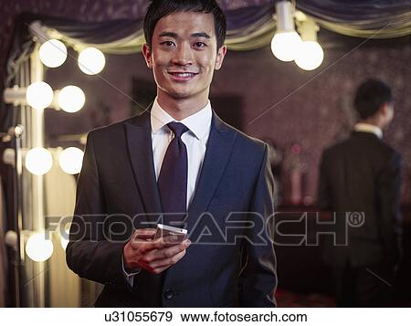 Stock Photo - Portrait of young man in new suit in traditional tailors shop. Fotosearch