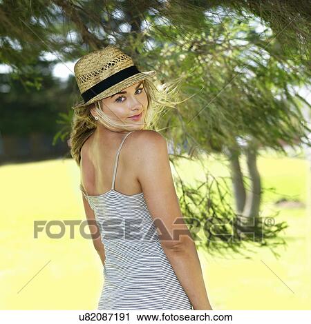 Stock Image - Portrait of young woman in park. Fotosearch