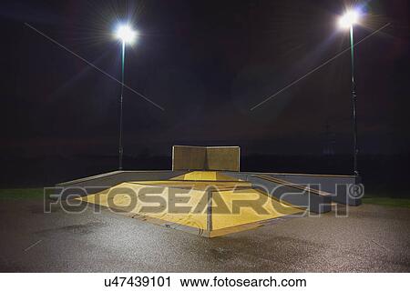 Stock Image - Ramp structures and skateboard park at night. Fotosearch