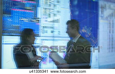 Stock Image - Reflection of business people in front of screens. Fotosearch