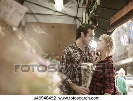 Stock Image - Romantic young couple at flower stall. Fotosearch