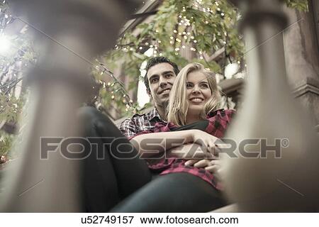 Stock Photo - Romantic young couple sitting on traditional city apartment steps. Fotosearch