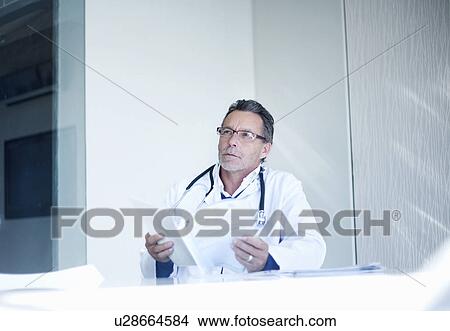 Senior male doctor holding medical records View Large Photo Image Picture - Senior male doctor holding medical records. Fotosearch