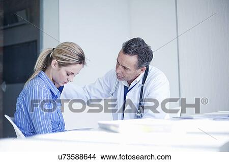 Senior male doctor sympathizing with patient View Large Photo Image Picture - Senior male doctor sympathizing with patient. Fotosearch