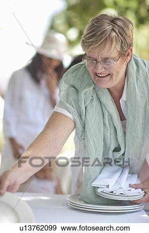 Senior woman setting table View Large Photo Image Stock Photo - Senior woman setting table. Fotosearch