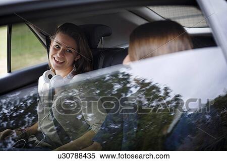 Stock Photography - Sisters chatting in car. Fotosearch