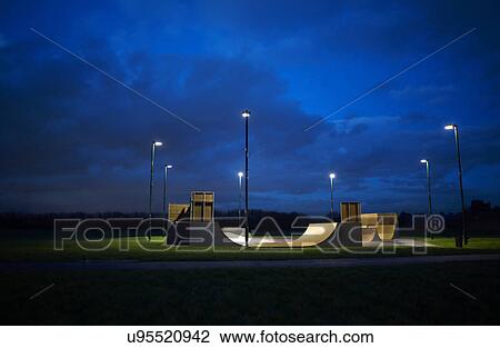 Stock Image - Skateboard park surrounded by a circle of lights at night. Fotosearch